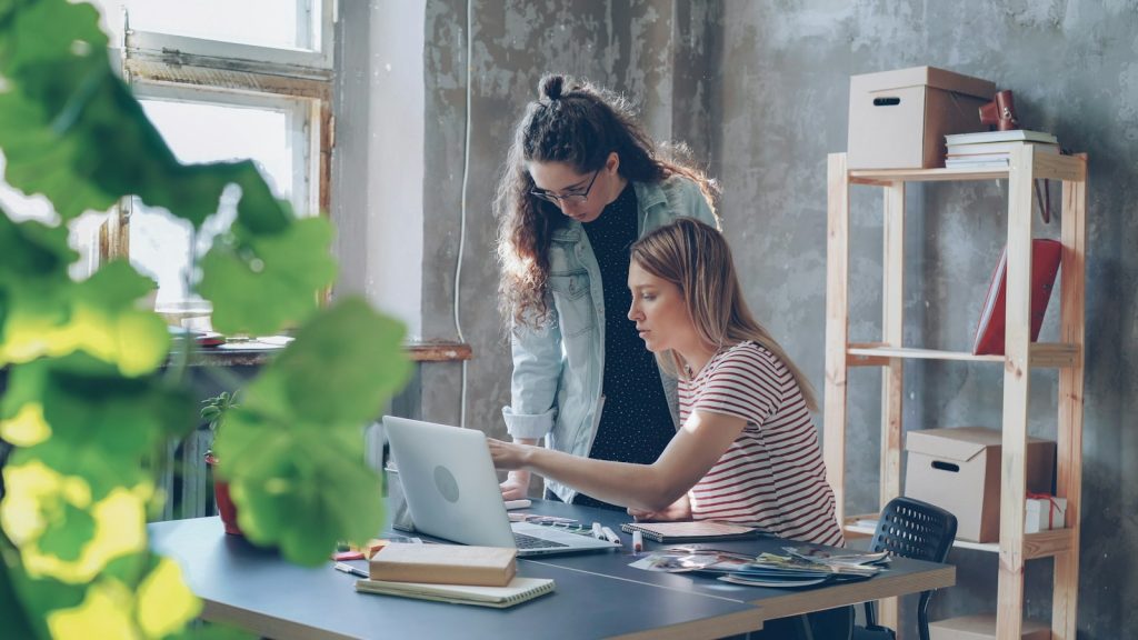 Design professionals collaborating on a laptop in an office